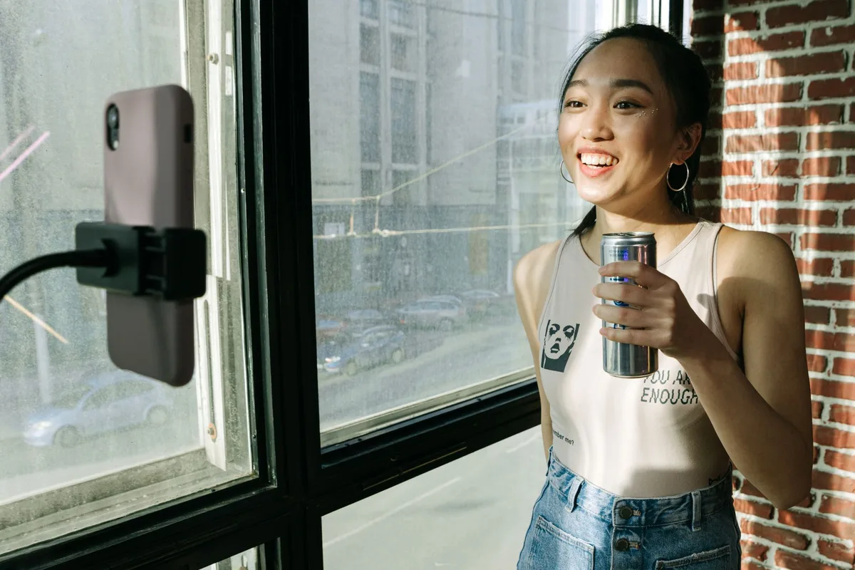 Mains tenant un smartphone affichant une interface de livestream avec produit et messages de chat