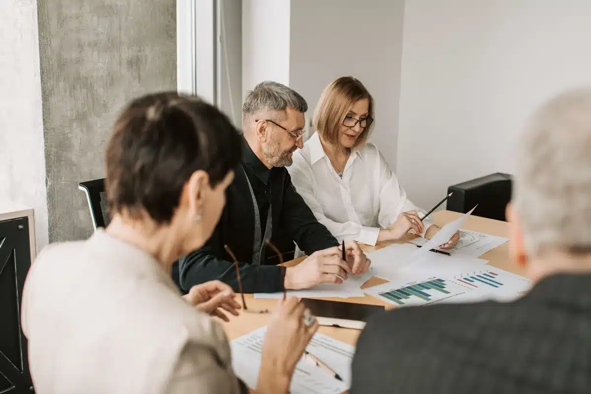 Équipe marketing discutant autour d'une table avec données concurrentielles affichées