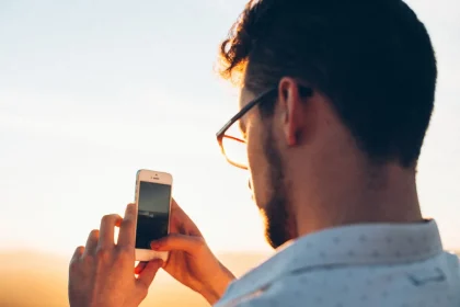Mains tenant un téléphone affichant des graphiques de mémoire et de performance en hausse