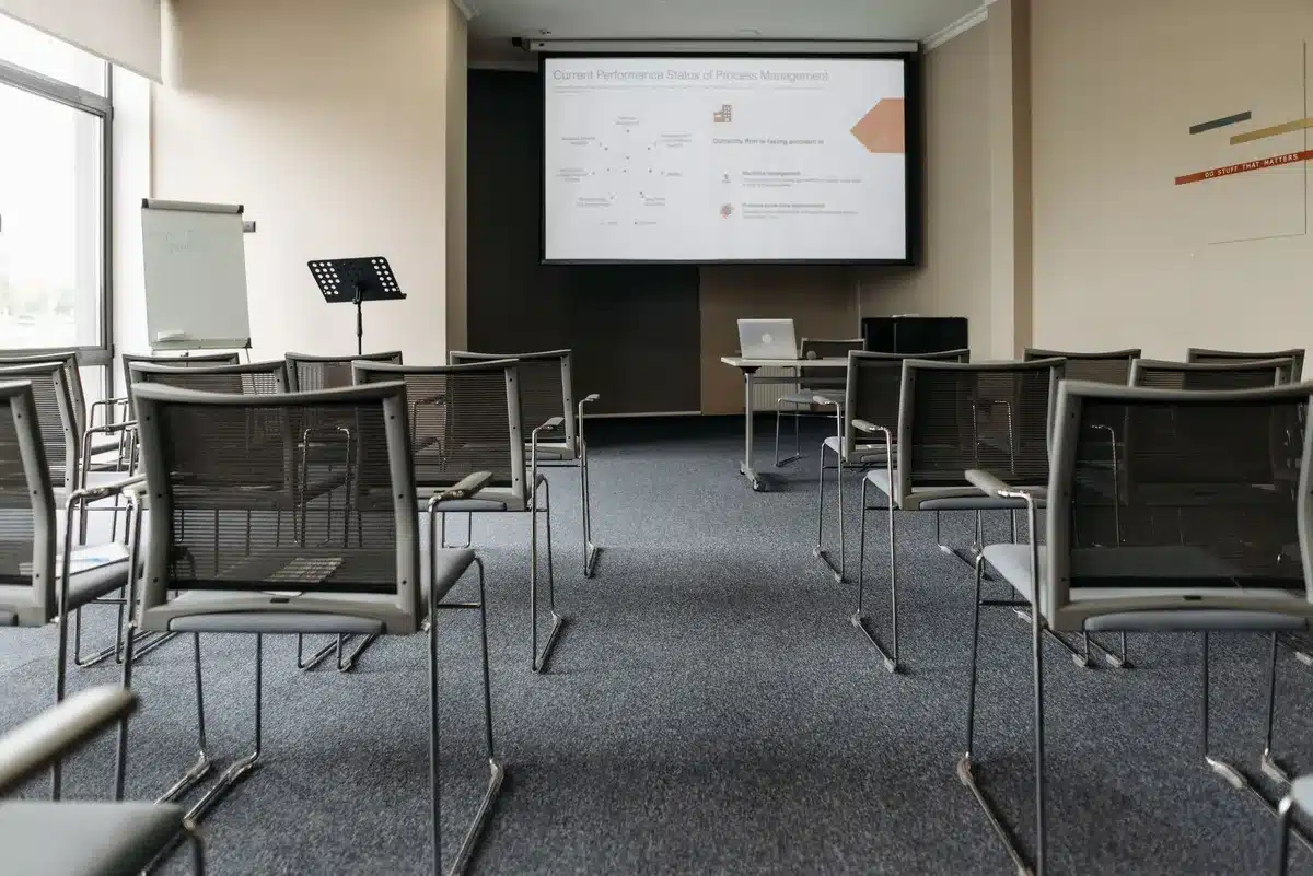 Groupe d'employés suivant une formation pratique sur un logiciel métier en petit groupe