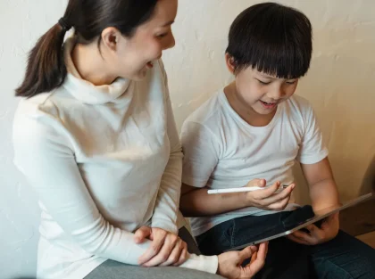 Enfant utilisant une application d'apprentissage interactif sur tablette avec un adulte à proximité
