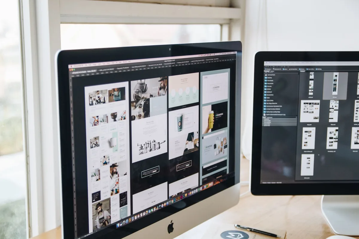 Espace de travail de designer avec deux écrans affichant des outils de génération visuelle et de gestion de projet