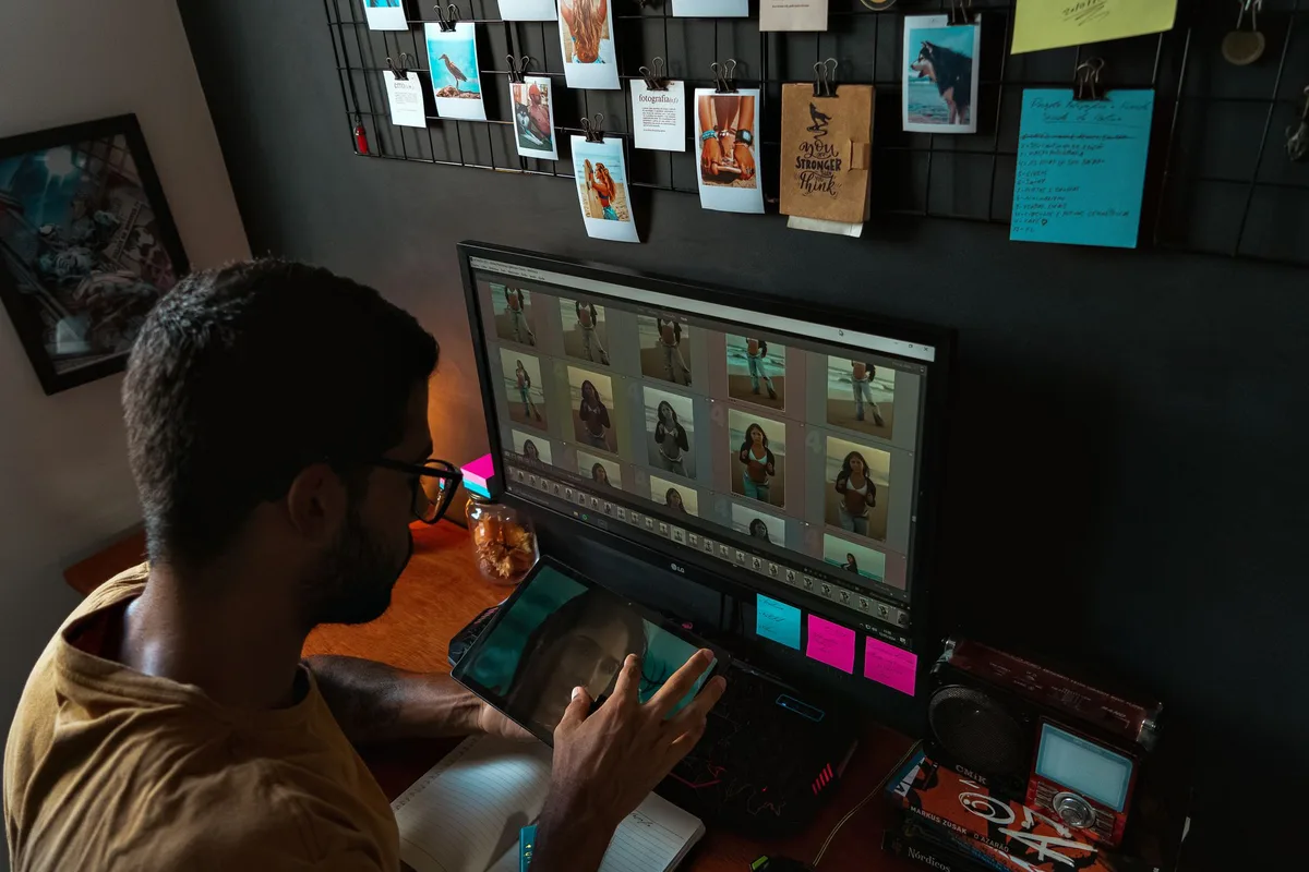 Mains organisant des photos et de la musique sur un bureau avec ordinateur portable en arrière-plan