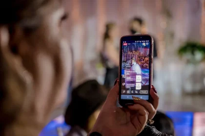 Mains tenant un smartphone affichant une vidéo en lecture, symbolisant la consommation vidéo moderne