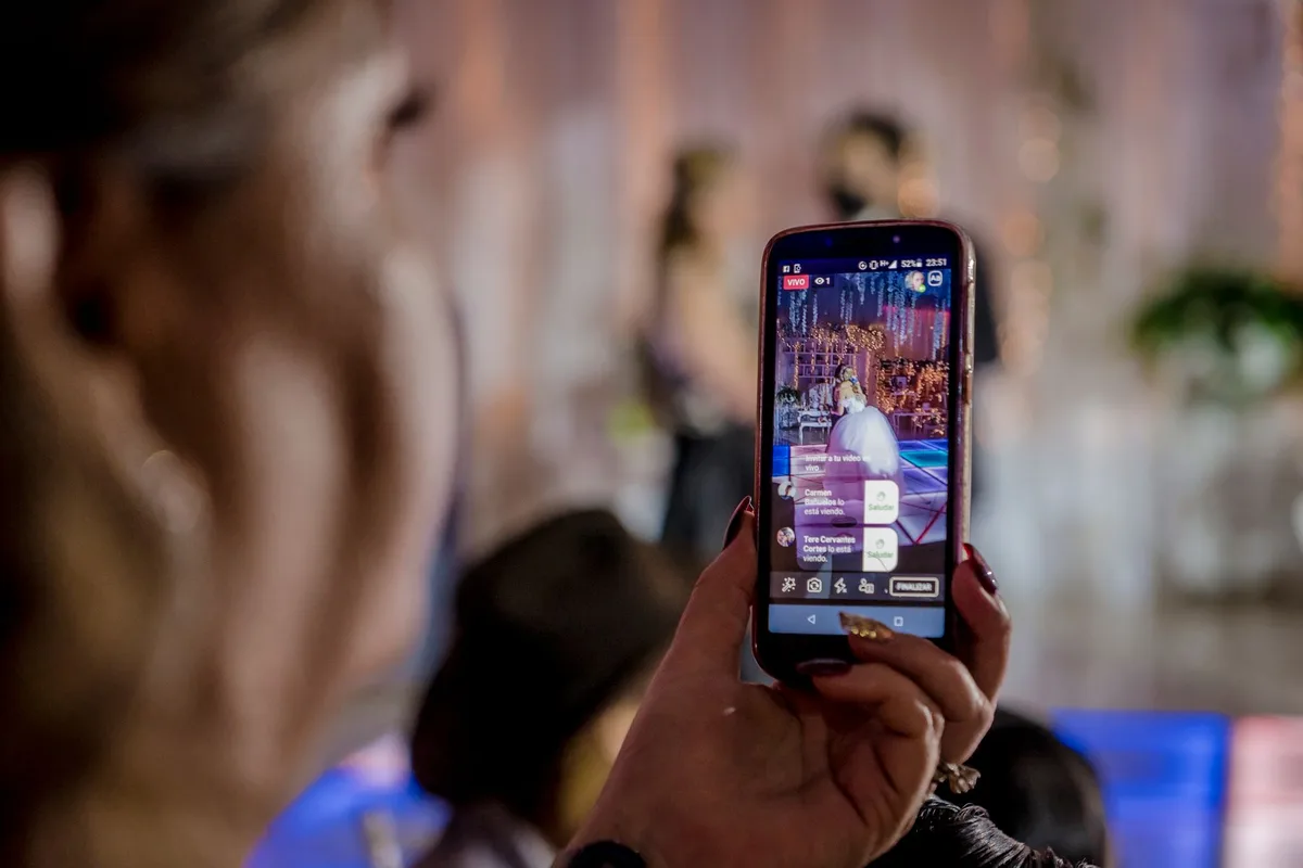 Mains tenant un smartphone affichant une vidéo en lecture, symbolisant la consommation vidéo moderne