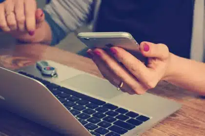 Smartphone affichant une application financière posé sur un bureau avec carnet et tasse