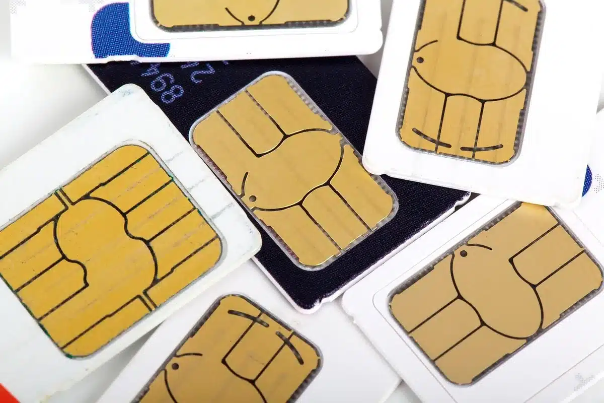 Retrait d'une carte SIM d'un smartphone posé près d'une fenêtre