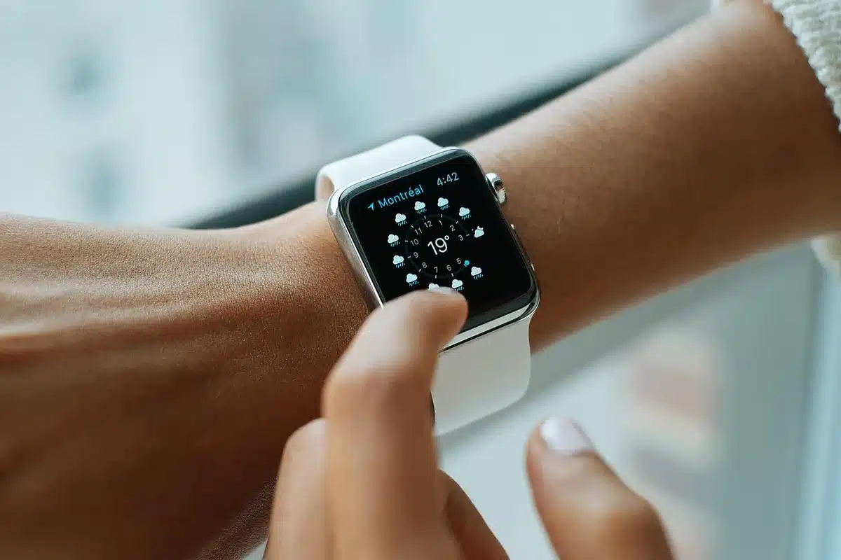 Montre connectée positionnée près d'un terminal de paiement pour effectuer une transaction.