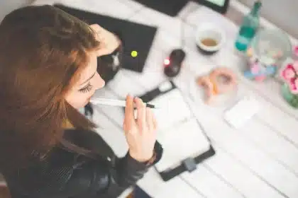 Bureau en journée avec contrat imprimé, ordinateur portable et mains pointant une clause
