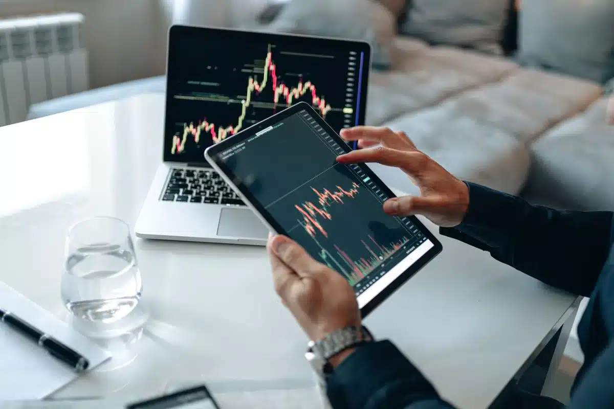 Ordinateur portable affichant graphiques de cryptomonnaie et documents explicatifs