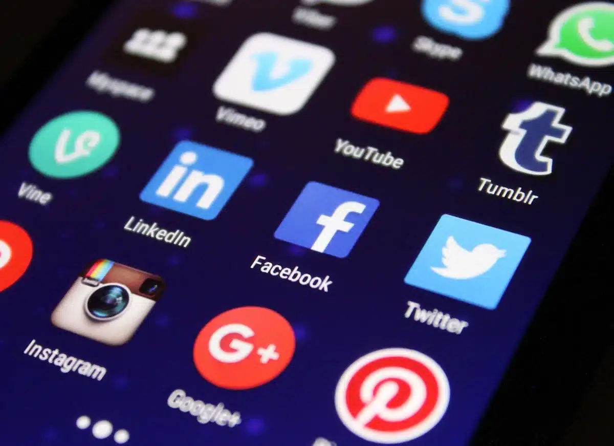 Personne créant du contenu sur un téléphone mobile avec des éléments personnels visibles.