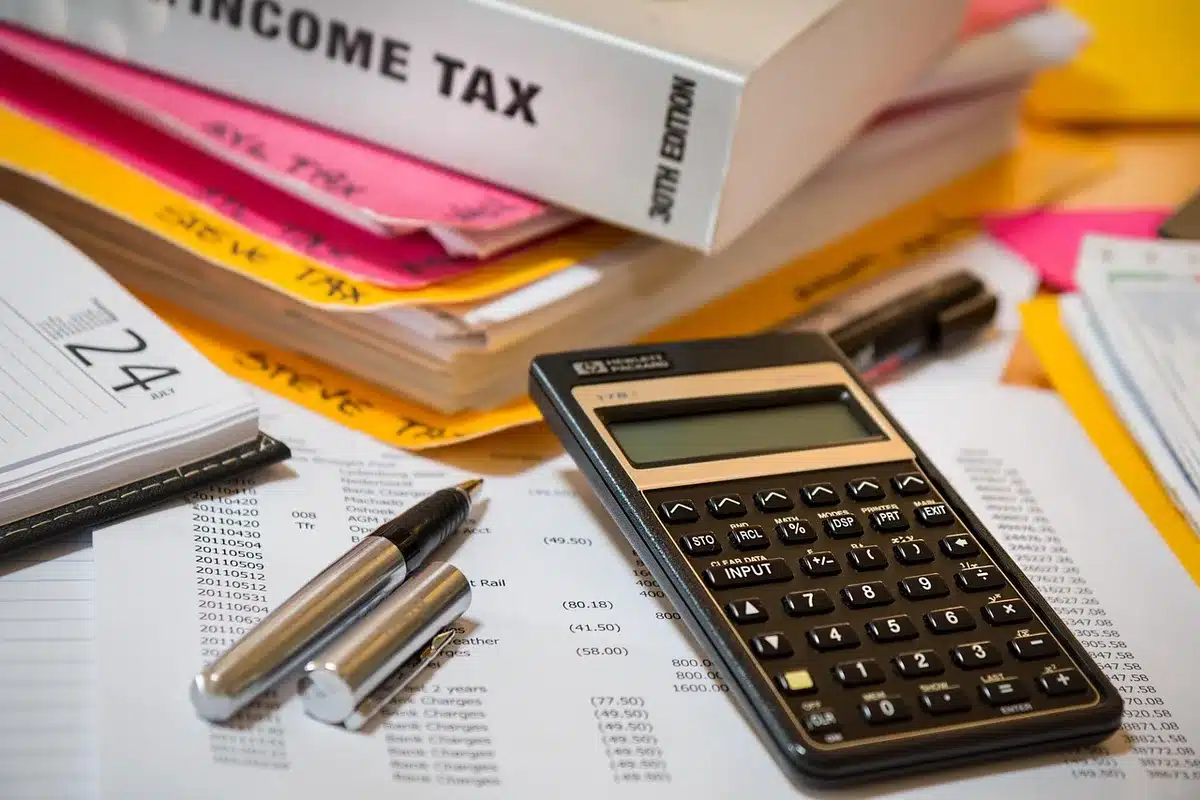 Reçus et calculatrice posés sur une table pour comparer dépenses
