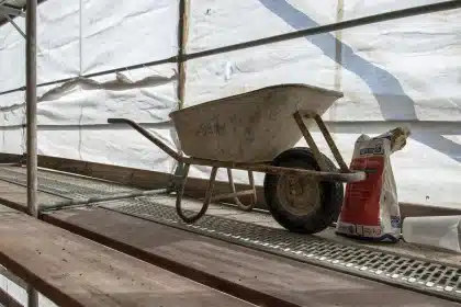 Chantier de démolition en journée avec mains triant des planches et portes pour réemploi