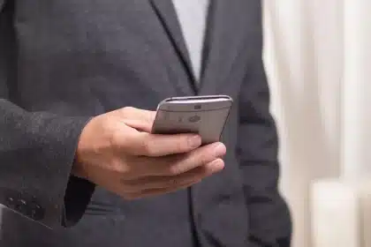 Tableau de bord de voiture avec écran tactile et smartphone posé, en pleine journée
