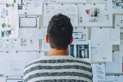 Designer arranging site mockups and a tablet showing unbranded educational template in a bright studio