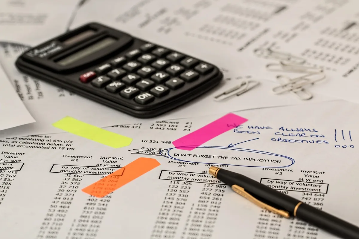 Grand livre comptable, calculatrice et factures sur un bureau