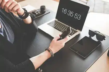 Espace de travail tech en journée avec ordinateur, schémas et tablette floue