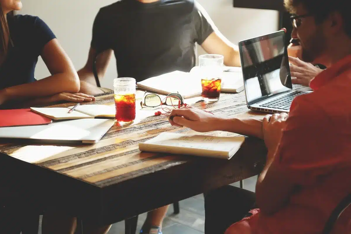 Ordinateur portable et carnet montrant un brainstorming assisté par IA